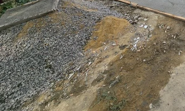 Fresh concrete poured in the entrance courtyard, July 2026