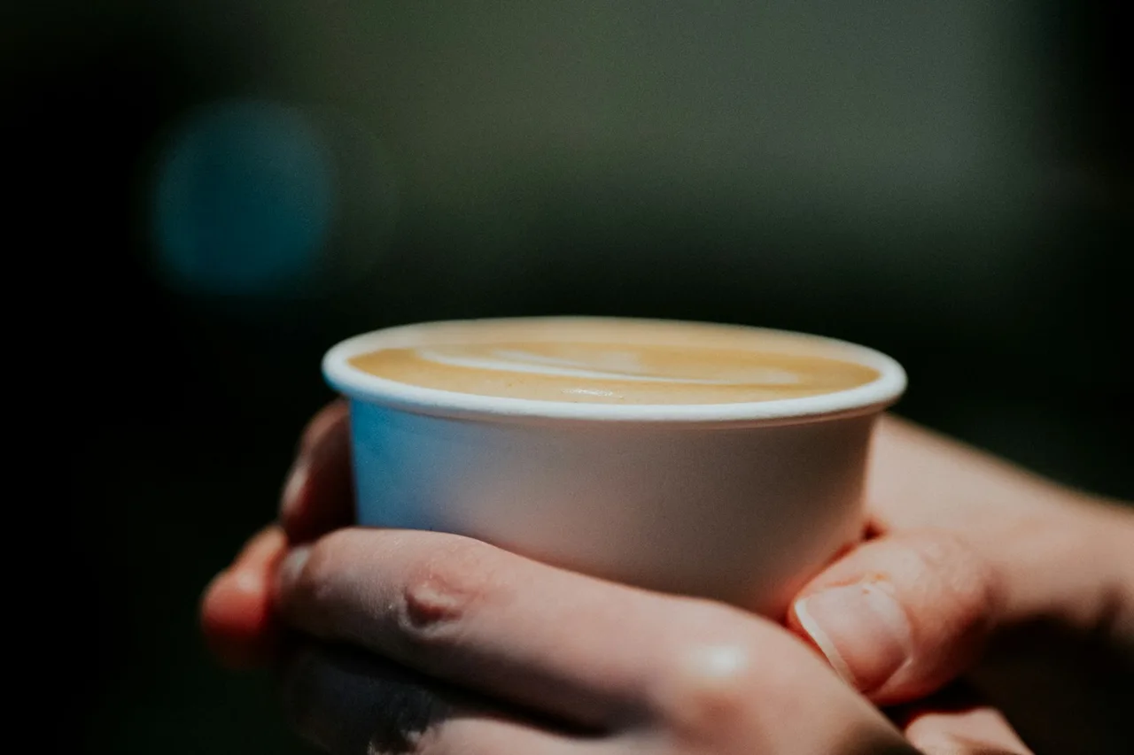 Hands holding a warm cup of coffee