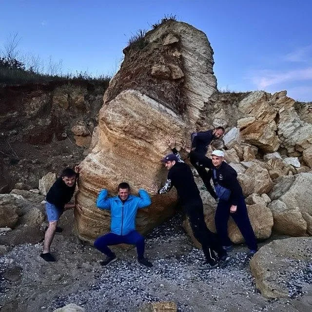People together beside rocks on the coast